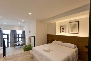 A hotel room with a large bed, a dining area with a table and chairs, and a balcony with a view. - One Tower Loft 08 (Valencia)