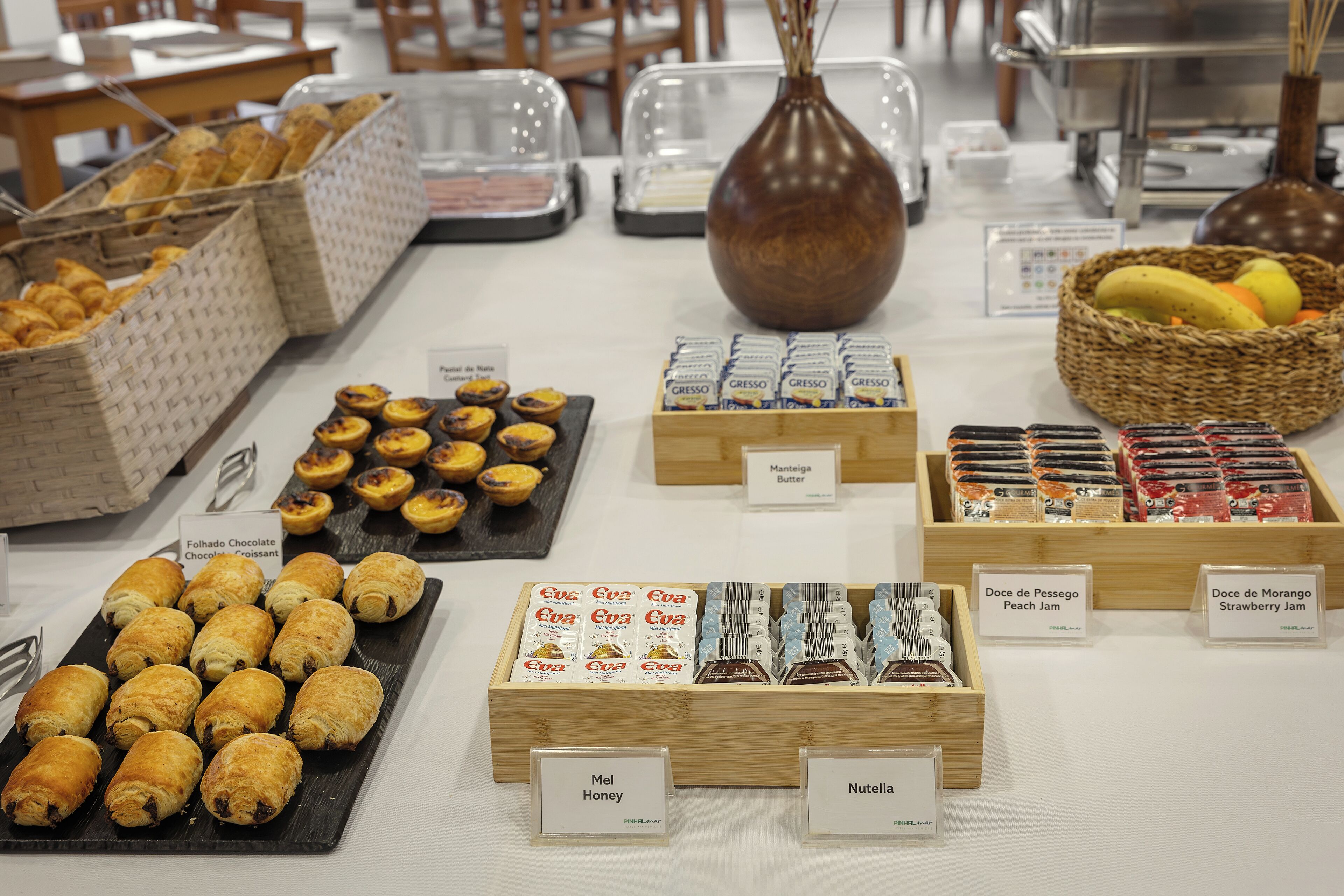 A buffet with various food items including pastries, jams, and honey.