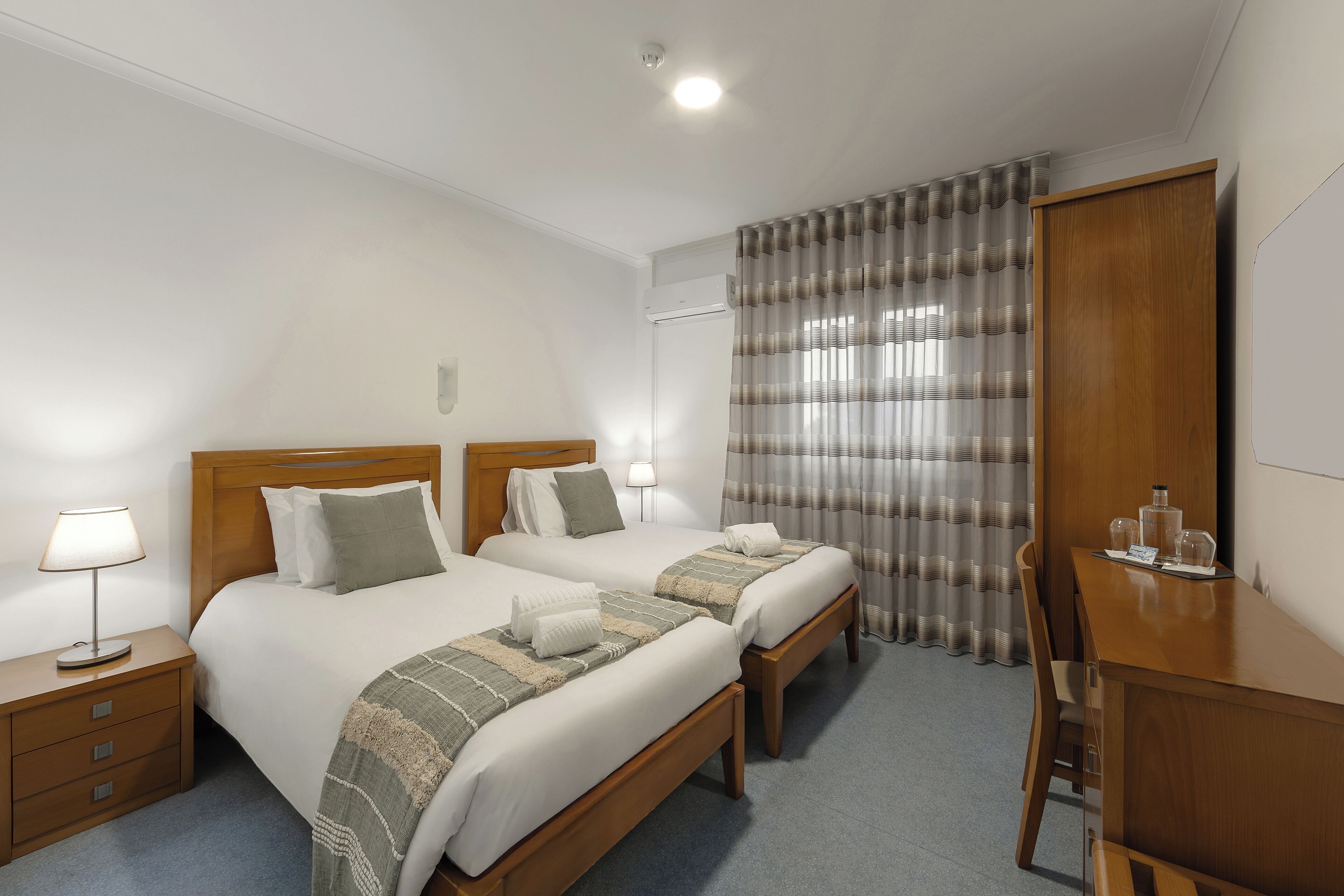Una habitación de hotel con dos camas, un escritorio y una silla.