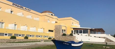 A building with a yellow facade and a blue boat in front.
