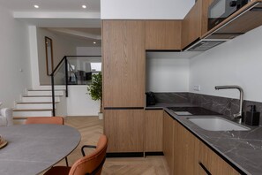 Une cuisine moderne avec des meubles en bois, un plan de travail noir et un évier.