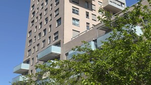 A tall, multi-story building with a modern architectural design, featuring balconies and a mix of window styles. - Plaza Tower Loft 10 (Valencia)