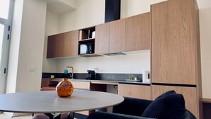 A modern kitchen with wooden cabinets, a microwave, and a coffee machine. - Plaza Tower Loft 10 (Valencia)