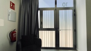 A room with a door, a fire extinguisher, and a window. - Plaza Tower Loft 10 (Valencia)