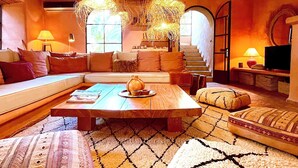 Uma sala de estar acolhedora com sofá, mesa de centro e luminárias pendentes.