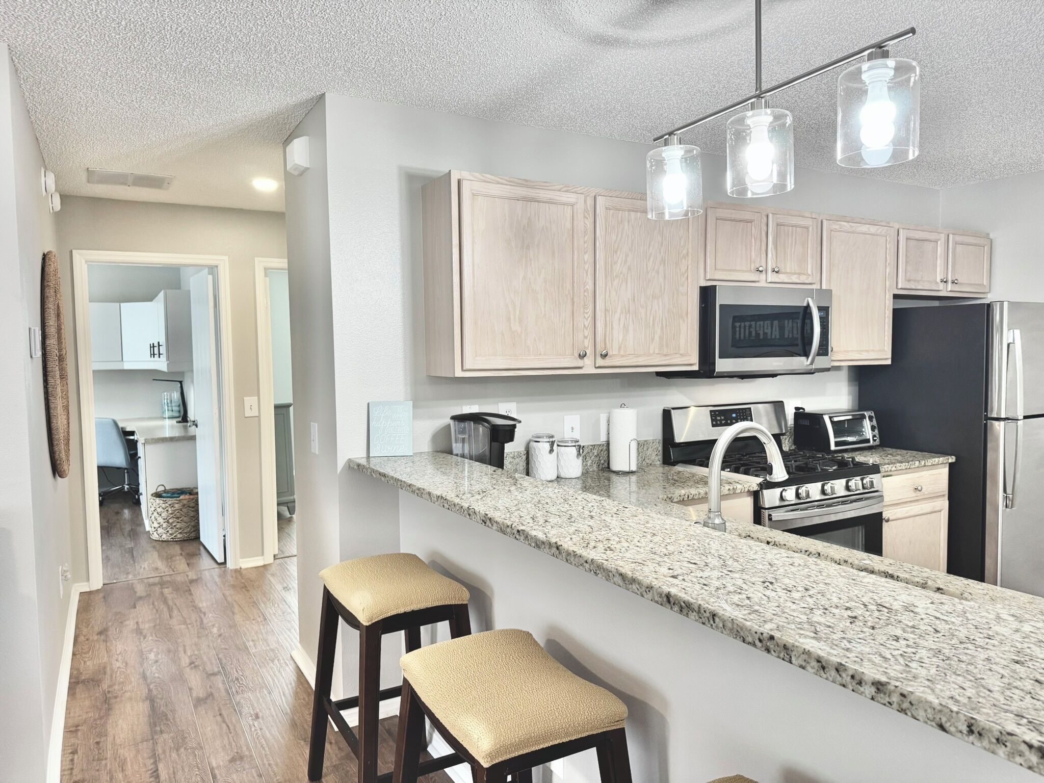 A modern kitchen with granite countertops, stainless steel appliances, and wooden cabinets.
