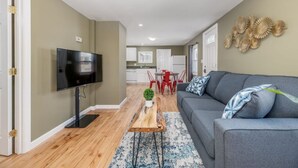 A modern living room with a grey sofa, a wooden coffee table, and a flat-screen TV. - Peaceful Bangor Getaway | Clean & Cozy 2BR Home (Bangor)