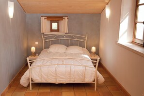A narrow room with a bed, two bedside tables, and a window with curtains. - Gîte la Maison du Randonneur (Castelnau-sur-l'Auvignon)