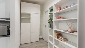 Une cuisine moderne avec des meubles blancs et une bibliothèque intégrée.