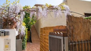 Une ruelle étroite, bordée d’une clôture en bois, d’un mur de briques et d’un bâtiment blanc doté d’un clavier à code pour le système de sécurité.