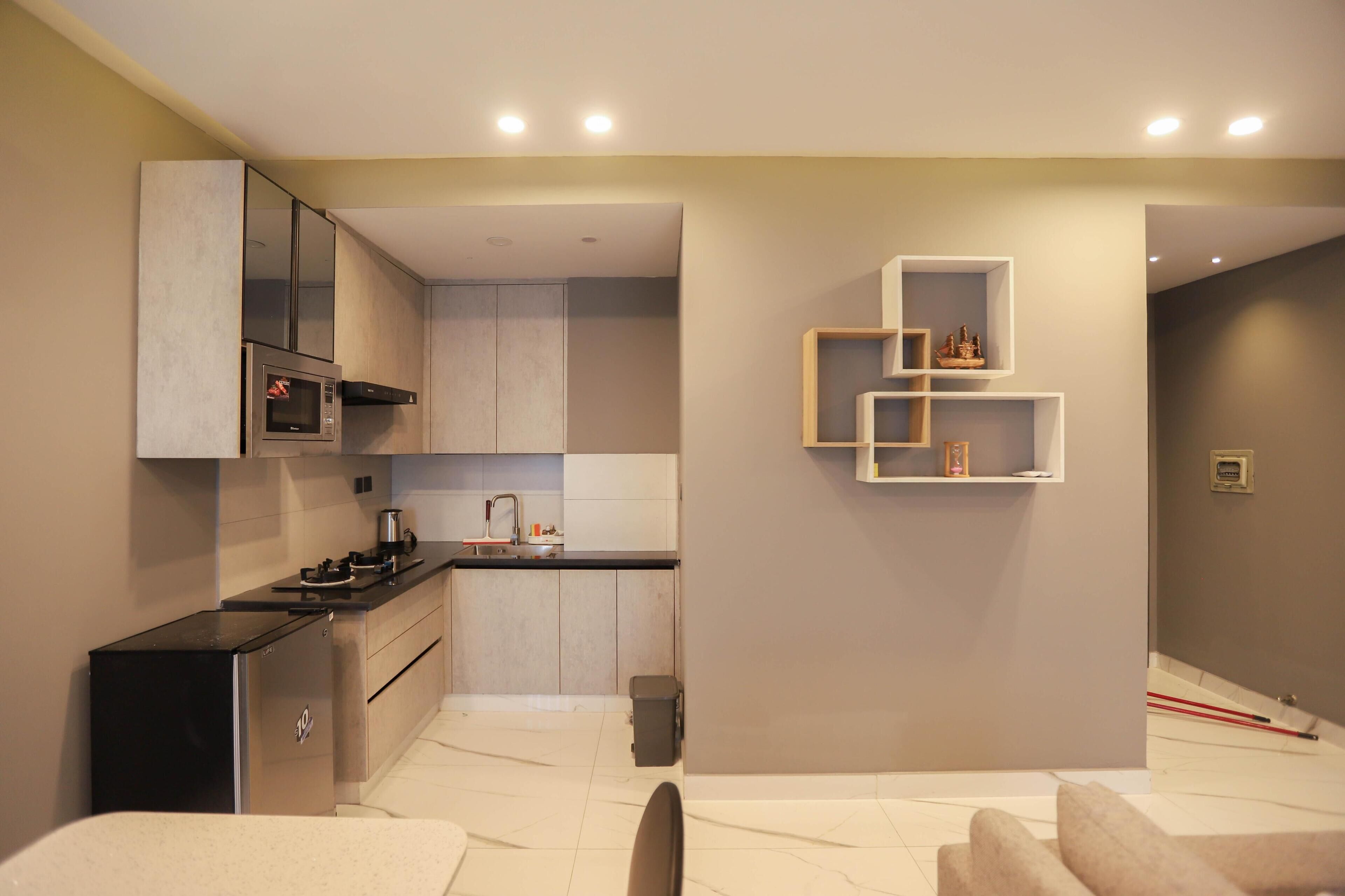 A modern kitchen with built-in appliances, a coffee machine, and a small refrigerator.