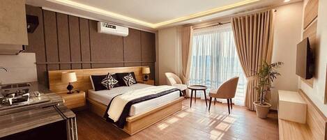 Una habitación de hotel moderna con una cama grande, un escritorio, una silla, un televisor y una planta en maceta.
