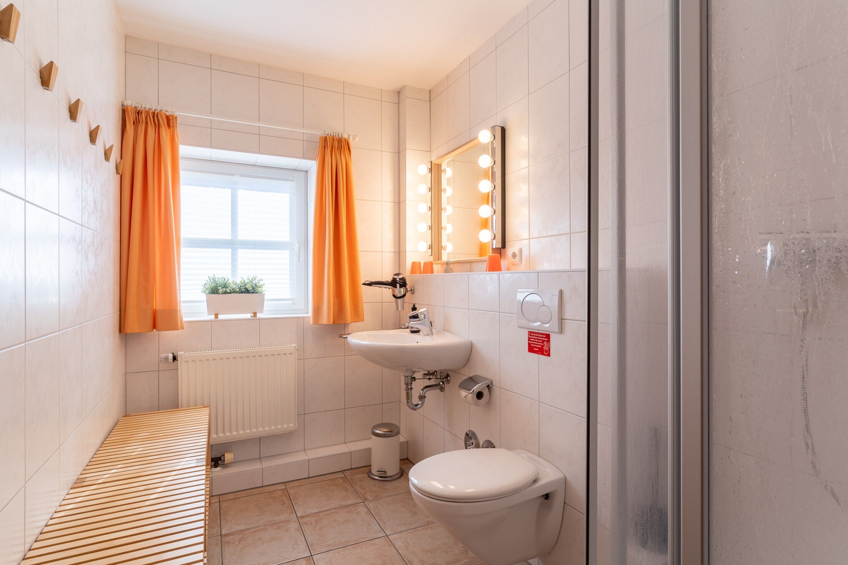 A bathroom with a sink, mirror, and toilet.