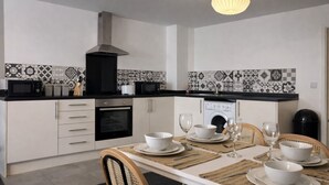 Une cuisine moderne avec des armoires blanches, un comptoir noir et un pare-feu décoré.