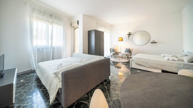 Een hotelkamer met een bed, een bureau, een stoel, een ronde tafel en een bank.