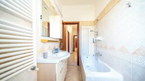 Een moderne badkamer met twee wastafels, een bad en een douche.