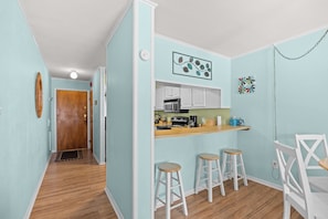 A compact kitchen with a wooden countertop, white cabinets, and a hanging light fixture. - Ocean Pier Unit 303 Sleeps 6-2br/2ba-Full Kitchen-Pool-Direct Oceanfront Balcony (North Myrtle Beach)