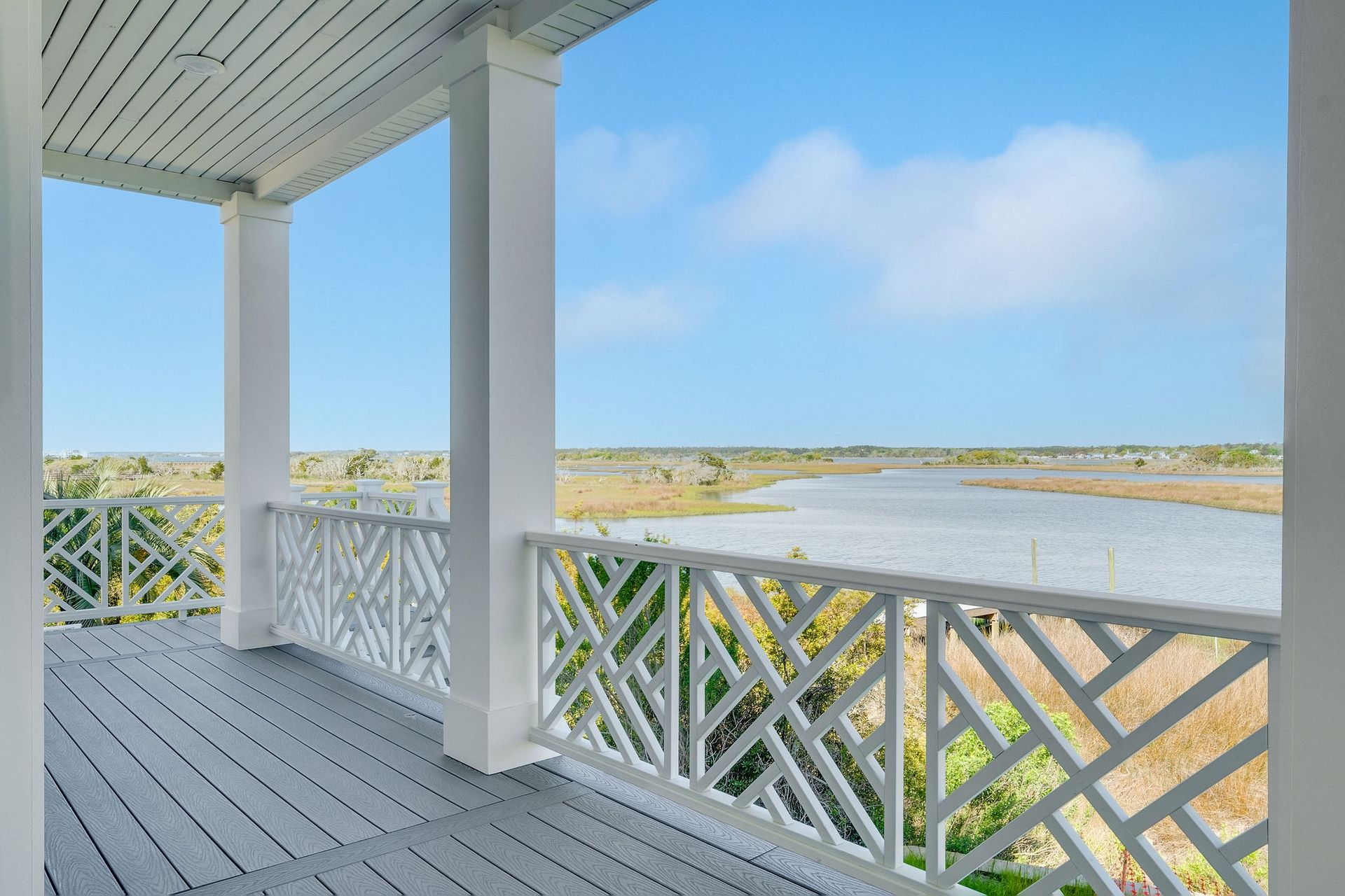 A covered outdoor area with a view of a water body and distant landscape.