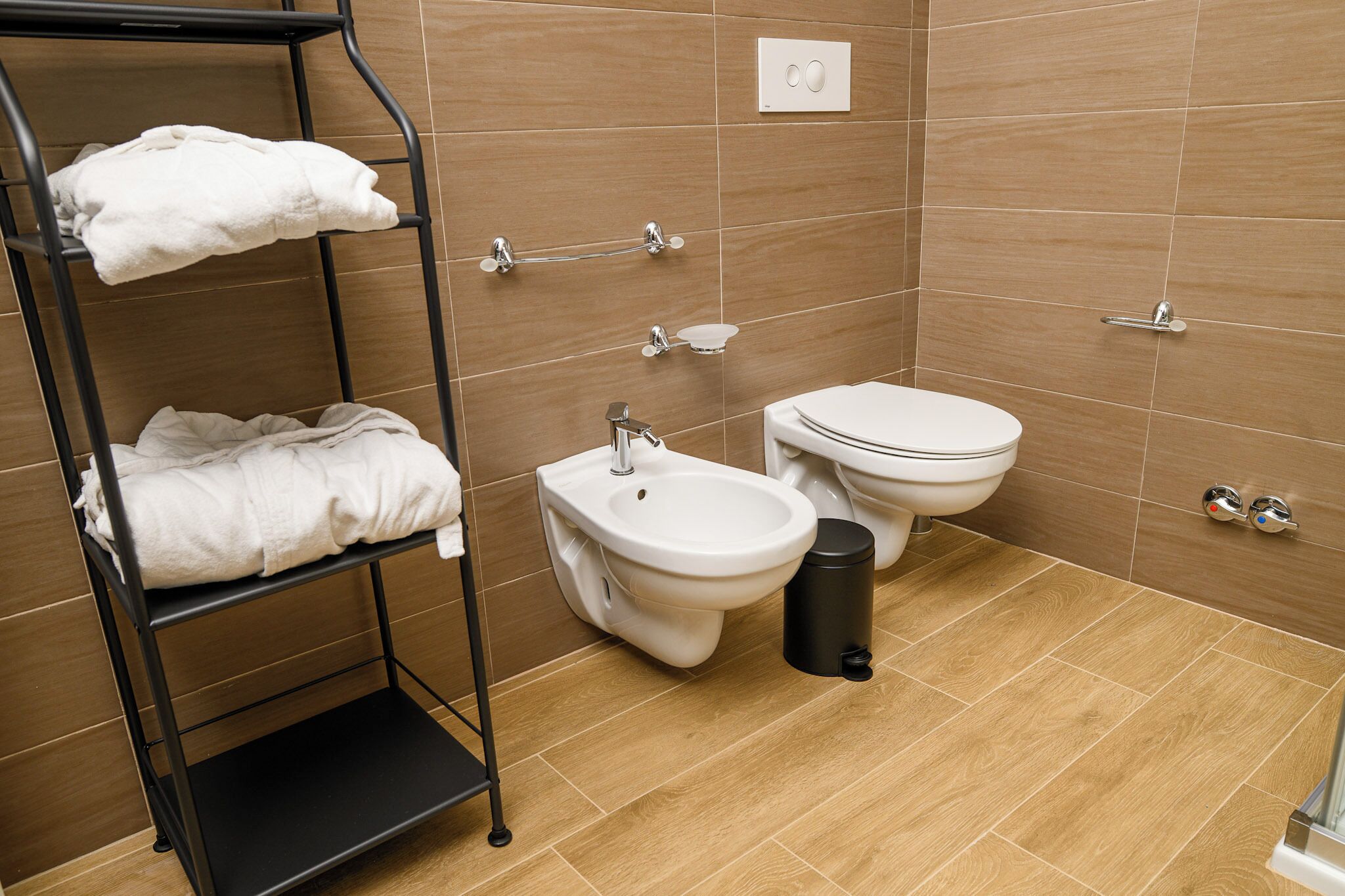 Un bagno con bidet, WC e portasciugamani.