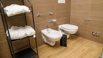 Un bagno con bidet, WC e portasciugamani.