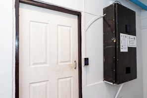 A door with a keypad lock and a contact information sign on the wall. - The Hidden Khaosan (Bangkok)