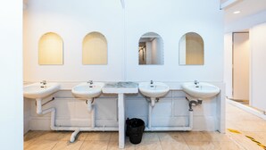 A public restroom with four sinks, each with a mirror above. - The Hidden Khaosan (Bangkok)