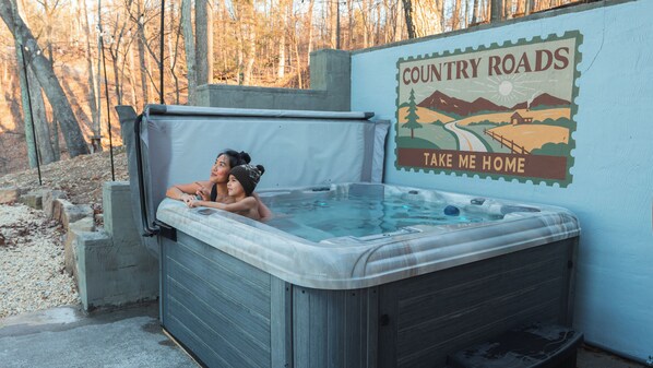 A hot tub with a 'Country Roads' sign in the background.