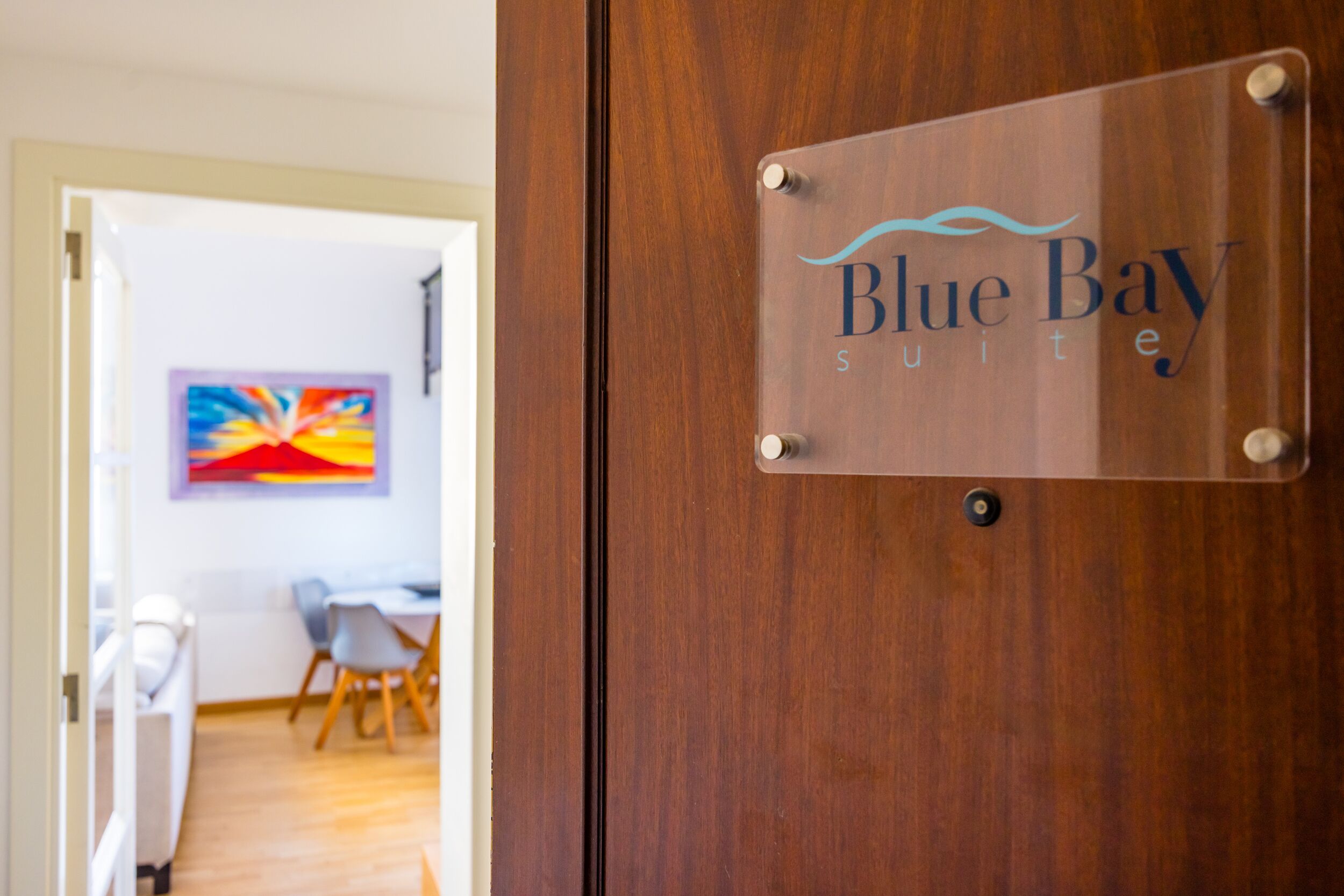Eine Holztür mit einer Glasplakette mit der Aufschrift 'Blue Bay Suites'.