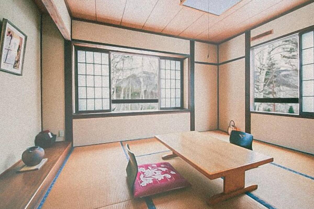 A traditional Japanese room with tatami flooring, a low wooden table, and sliding shoji doors.