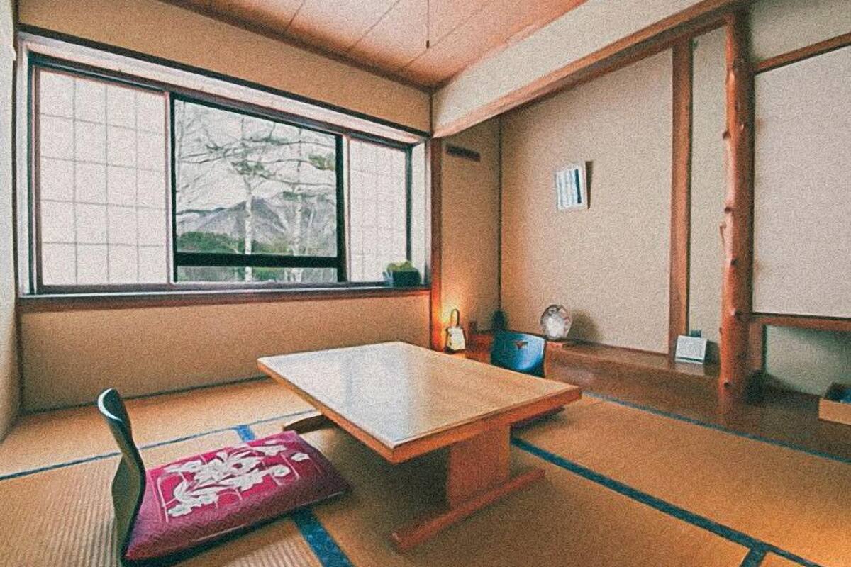 A traditional Japanese room with tatami flooring, a low wooden table, and a shoji screen.