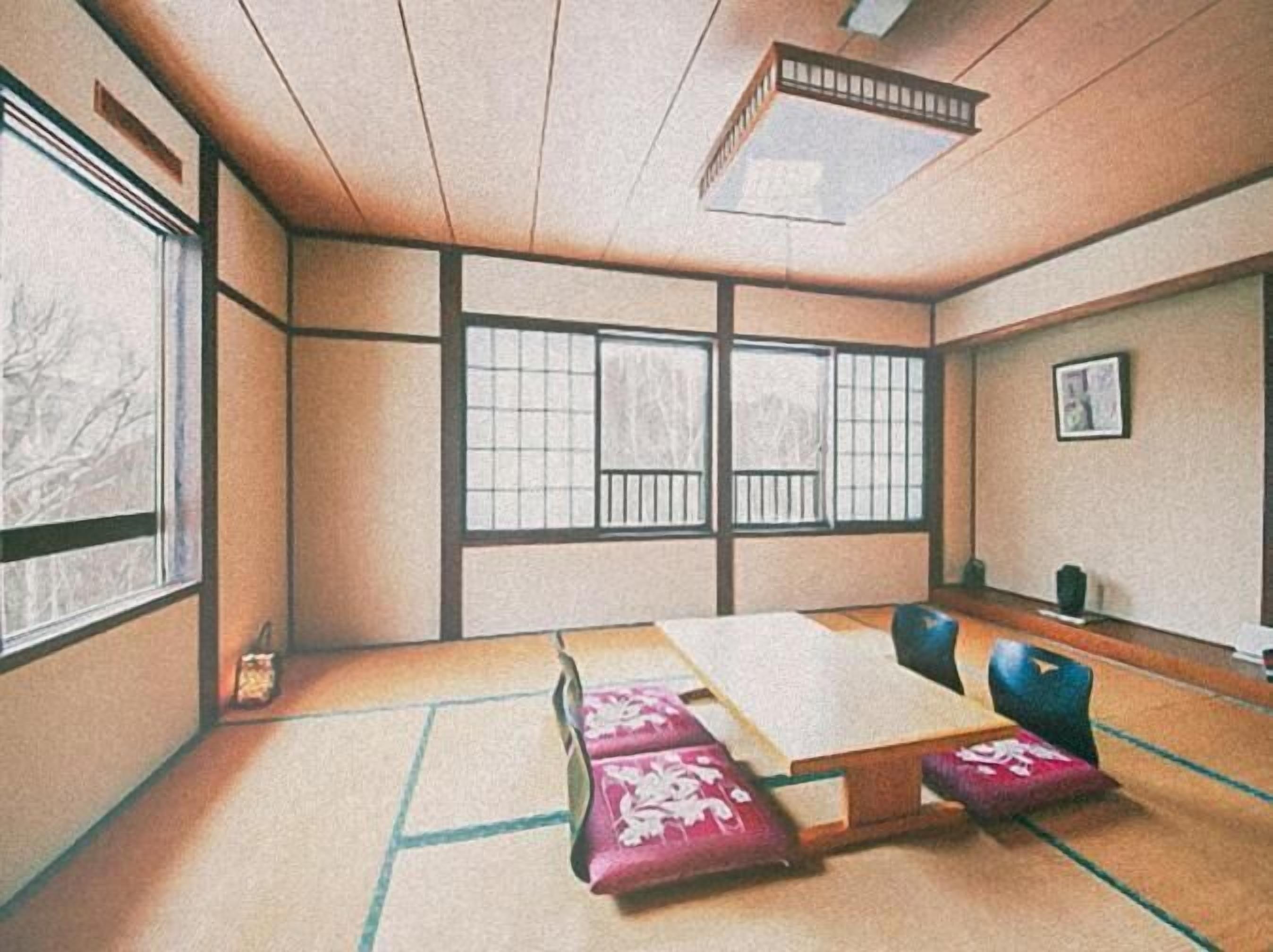 A traditional Japanese room with tatami flooring, shoji screens, and a low table with cushions.