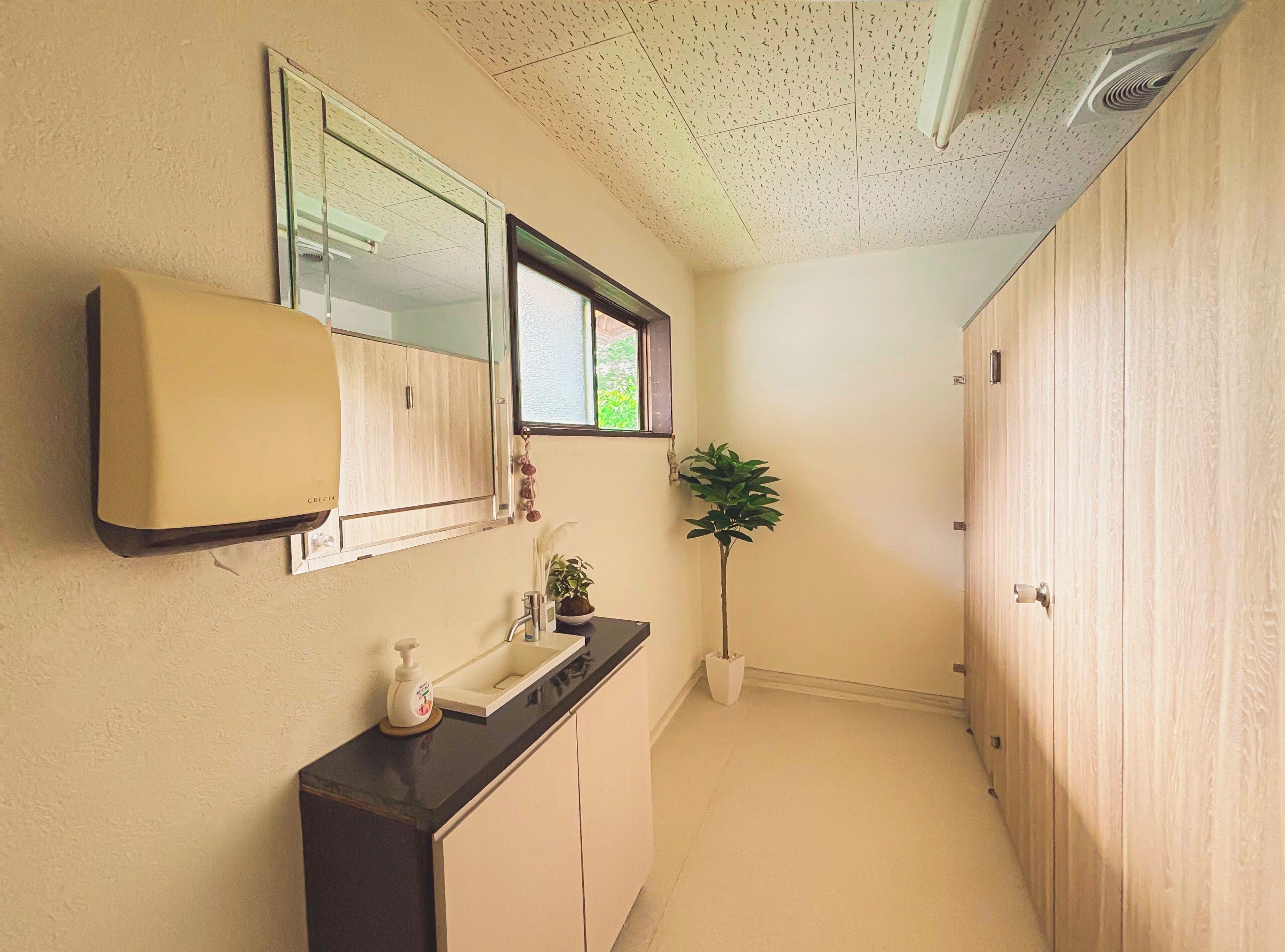 A narrow hallway with a bathroom featuring a sink, mirror, and cabinets.
