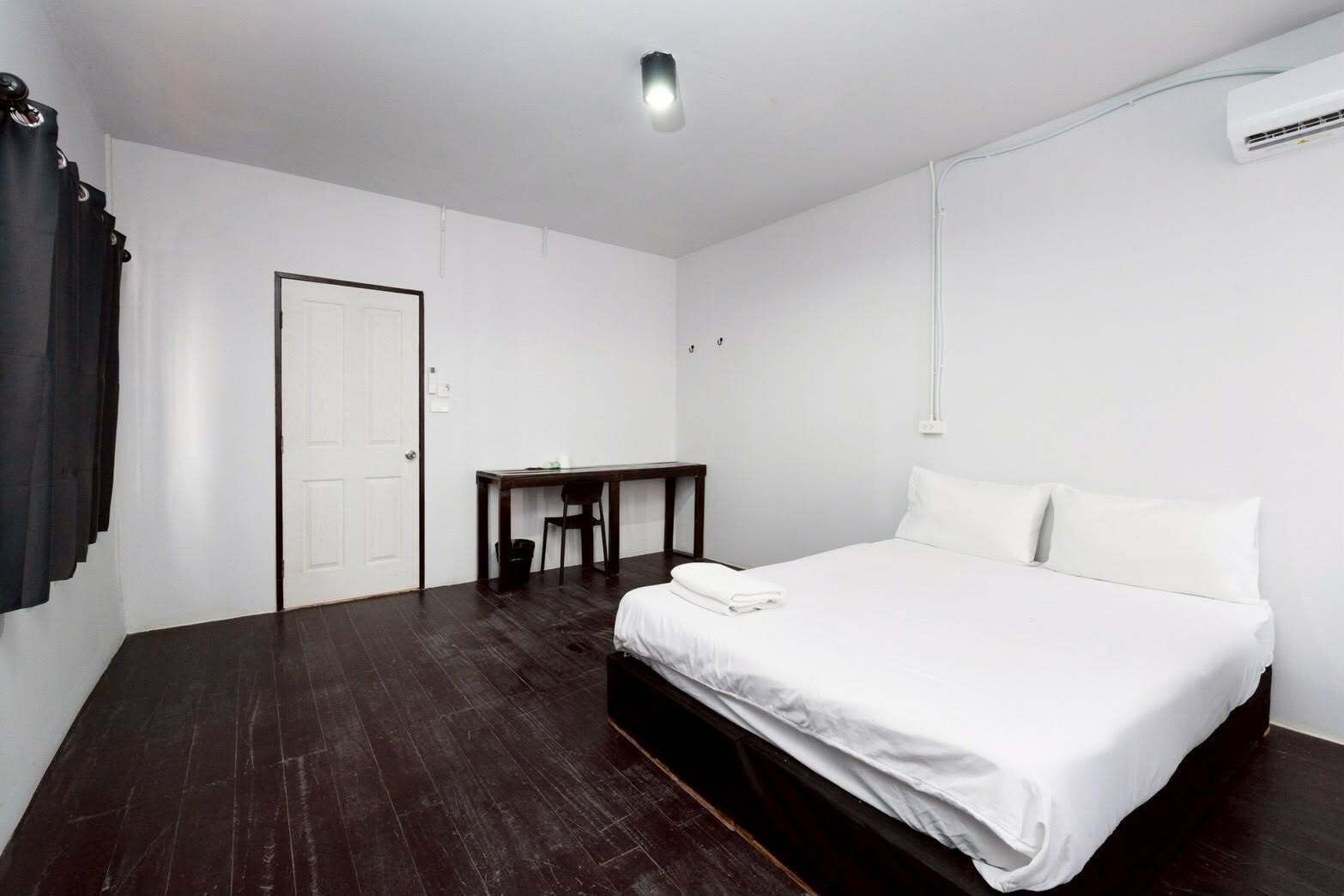 Une chambre d’hôtel avec un grand lit, un bureau et une chaise.