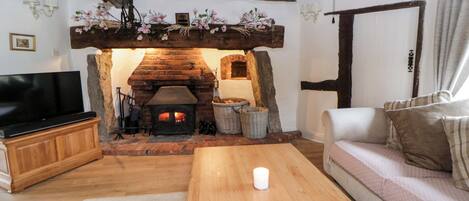 A cozy living room with a fireplace, a television, a sofa, and a coffee table.