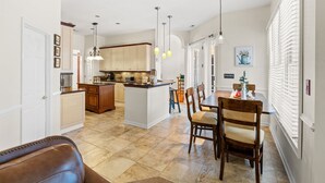 Una cocina amplia con una isla central, armarios de madera e iluminación colgante.