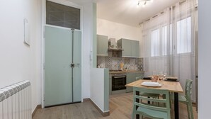 Eine kompakte Küche mit Essbereich, einem eingebauten Backofen und einer kleinen Kücheninsel.