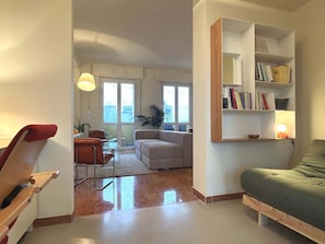A modern living room with a sofa, a chair, a coffee table, and a bookshelf. - Casa Matteo Elegant and Modern in Milan (Milan)