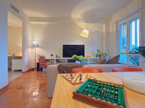 A modern living room with a wooden coffee table, a chessboard, a sofa, and a television. - Casa Matteo Elegant and Modern in Milan (Milan)