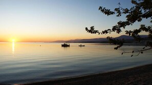 A calm lake at sunset with boats and distant mountains. - Sunshine Home - Peaceful Garden Escape Parking (Aigialeia)