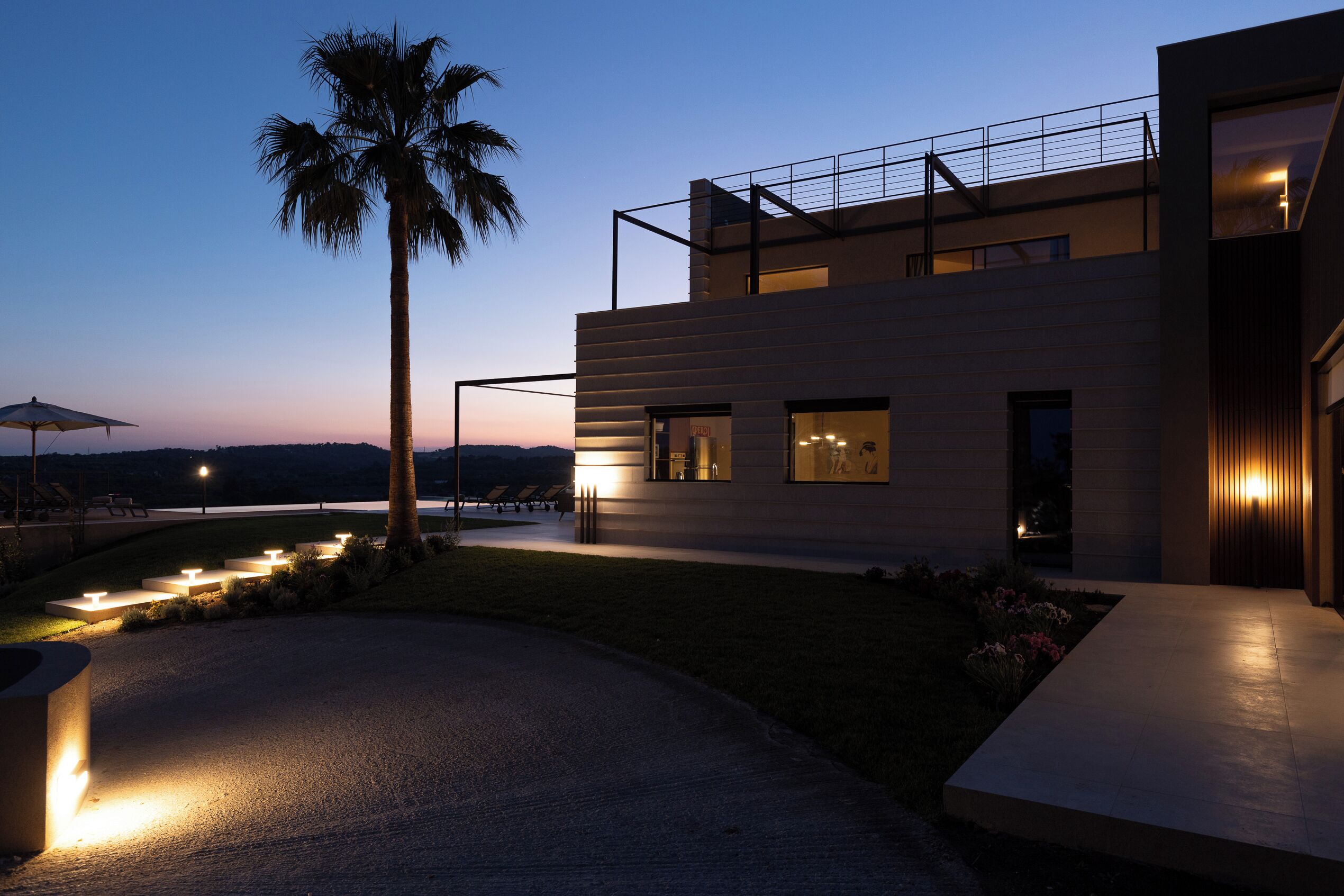 A modern building with a flat roof, large windows, and a well-lit exterior.