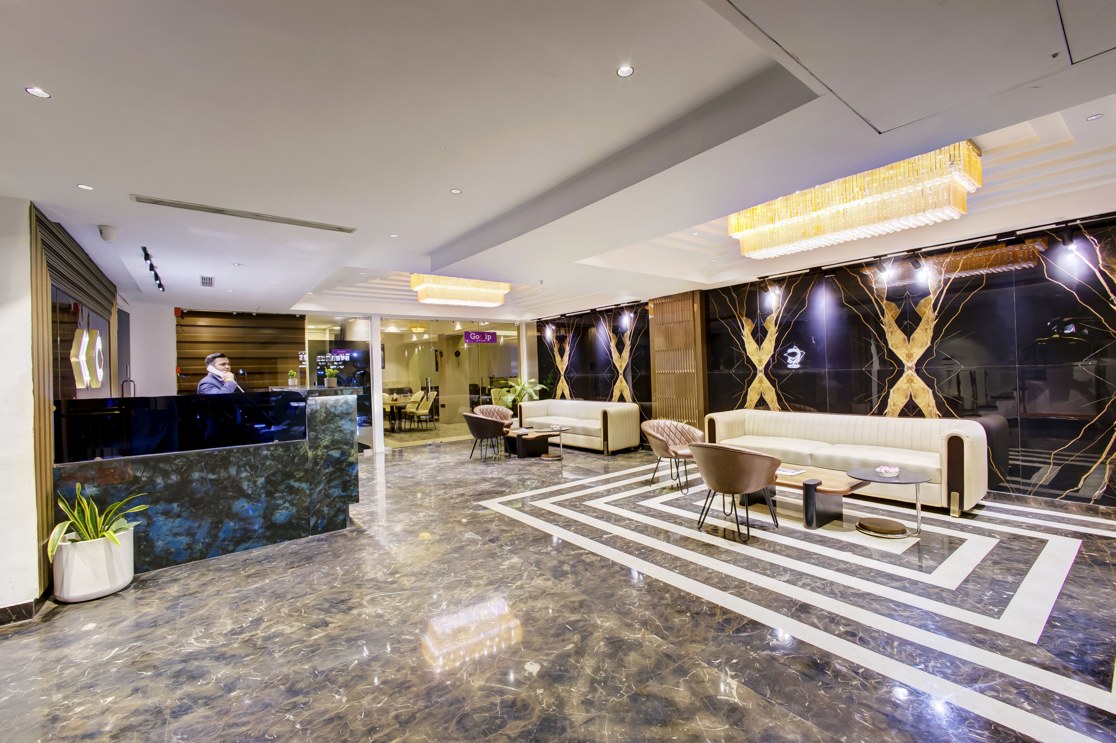 A hotel lobby with a reception desk, seating area, and modern decor.