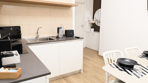 A modern kitchen with white cabinetry, a built-in oven, and a coffee maker. - L`Airone - Appartamento 2 (Campanarello)
