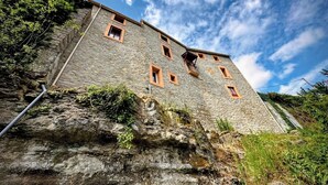 A stone building with multiple windows and a balcony. - Gîte La Bastide Saint-Roc Haute Vallée de l'Aude (Antugnac)