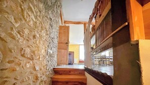 A narrow staircase with stone walls and wooden steps leading to a room with a large window and a wooden ceiling. - Gîte La Bastide Saint-Roc Haute Vallée de l'Aude (Antugnac)