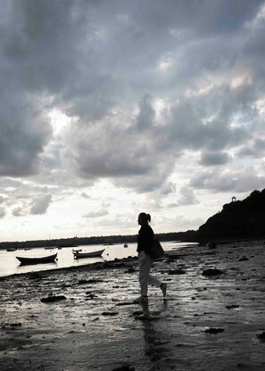 A person walking on a wet beach with boats in the water and a cloudy sky. - Cozy artist and fisherman cottage by the sea in St-Suliac village by Saint-Malo (Saint-Suliac)