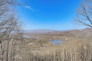 A river valley with mountains in the background and leafless trees in the foreground. - Lake Chatuge & Mtn Views! Hiawassee Cabin Retreat (Hiawassee)