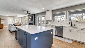 A modern kitchen with a central island, white cabinetry, and a dishwasher. - Waterfront Deck, Shell Knob Gem on Table Rock! (Shell Knob)