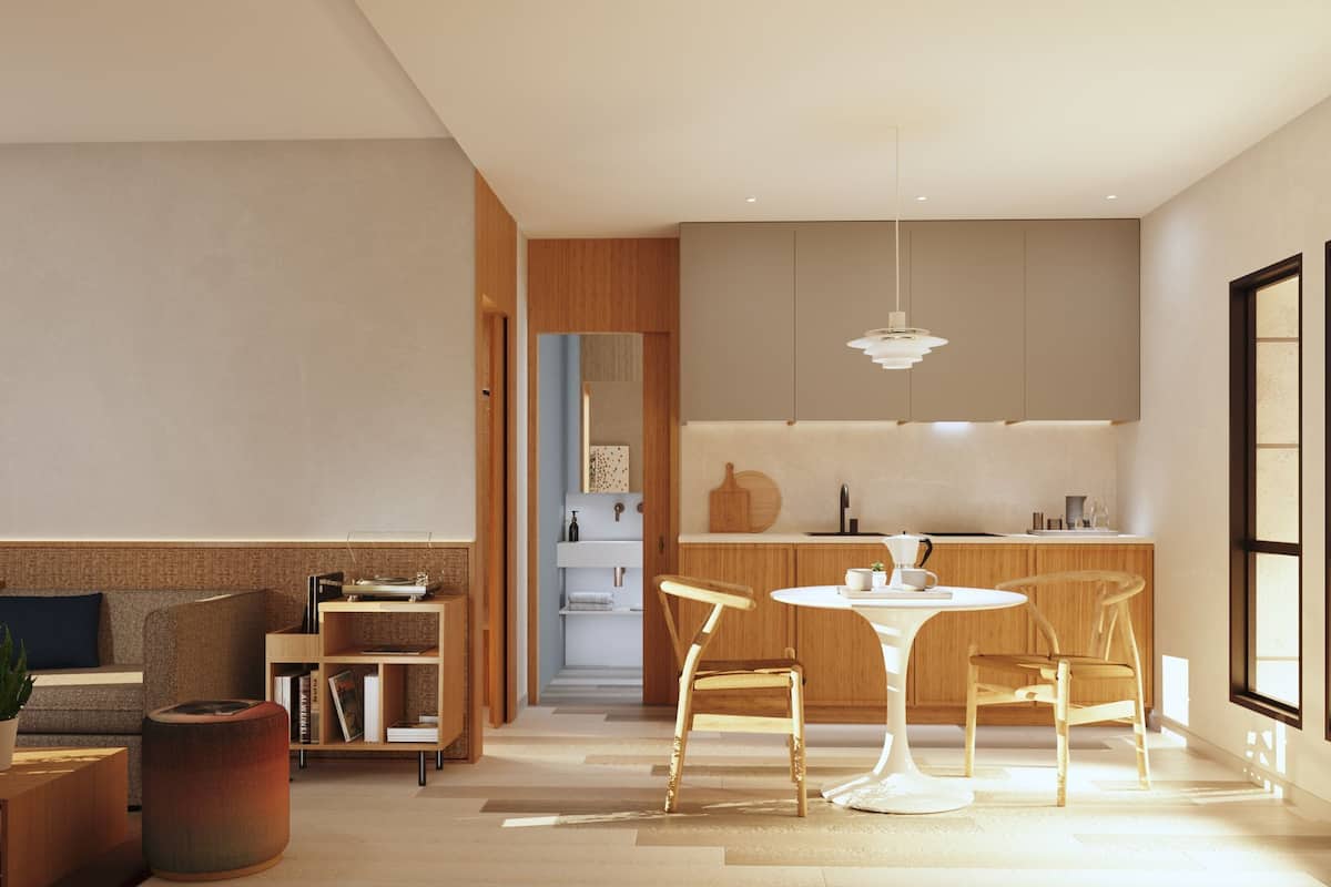 A modern living room with a sofa, coffee table, and bookshelf. There is a dining area with a table and chairs, and a kitchen with cabinets and a sink.