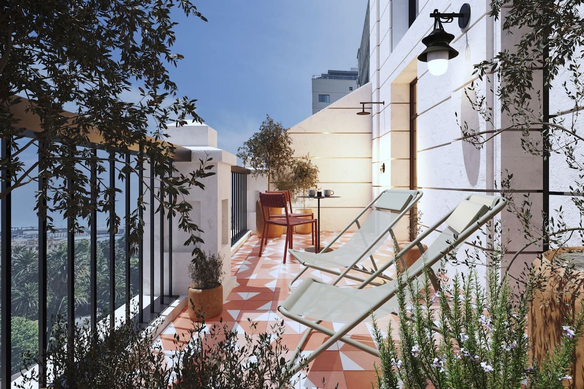 A balcony with a view of the city, a table with chairs, and potted plants.
