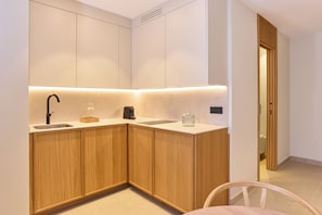 A modern kitchen with wooden cabinets, a sink, and a countertop. - Ocean Drive Málaga (Málaga)